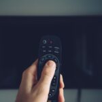 Male hand with TV remote controller